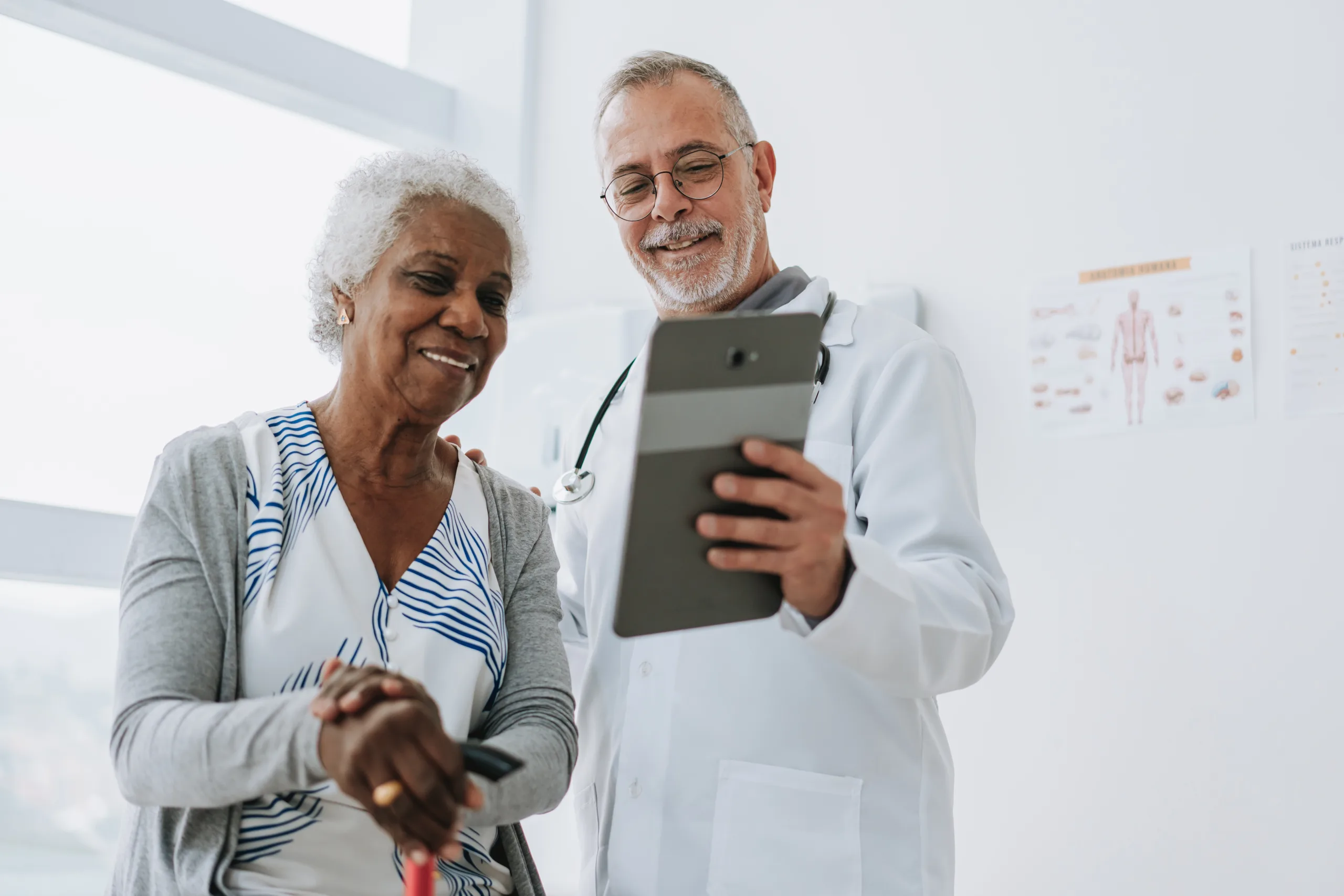 Doctor going over results on tablet with elderly patient