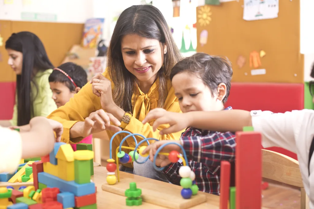 Teachers with children playing and learning at preschool