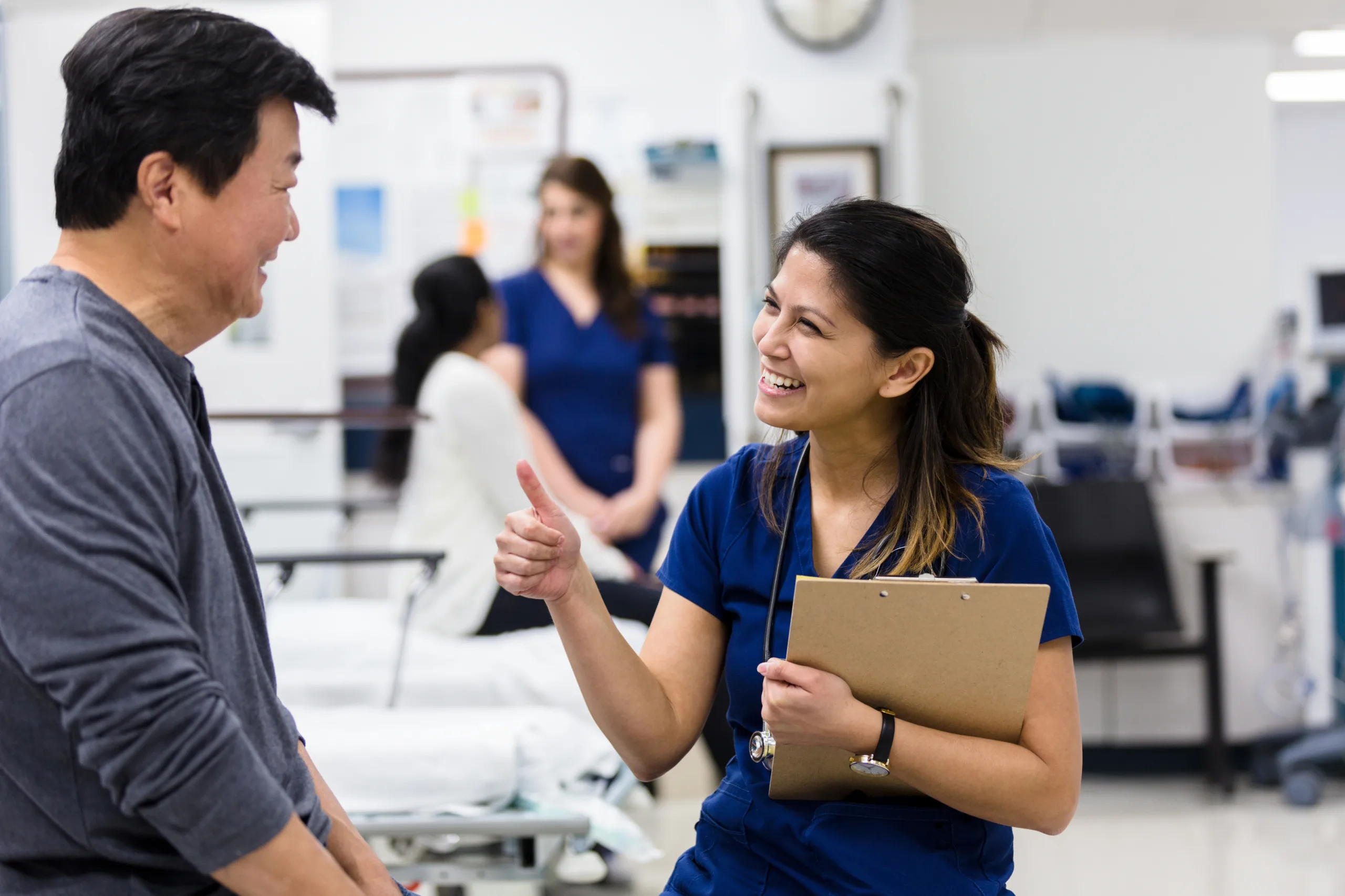 Nurse gives thumbs up to male patient in emergency room