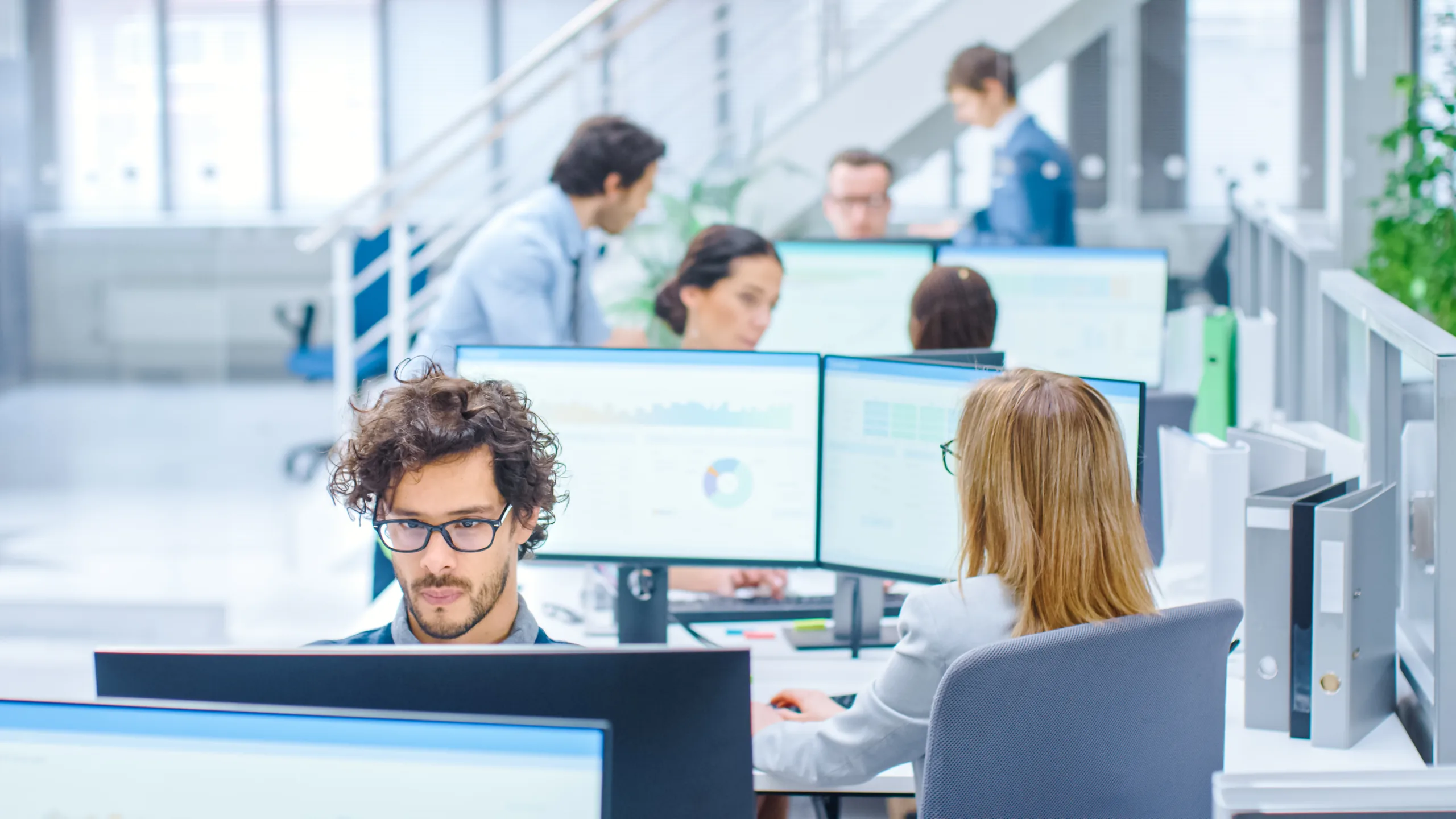 Office setting with business professionals working on computers