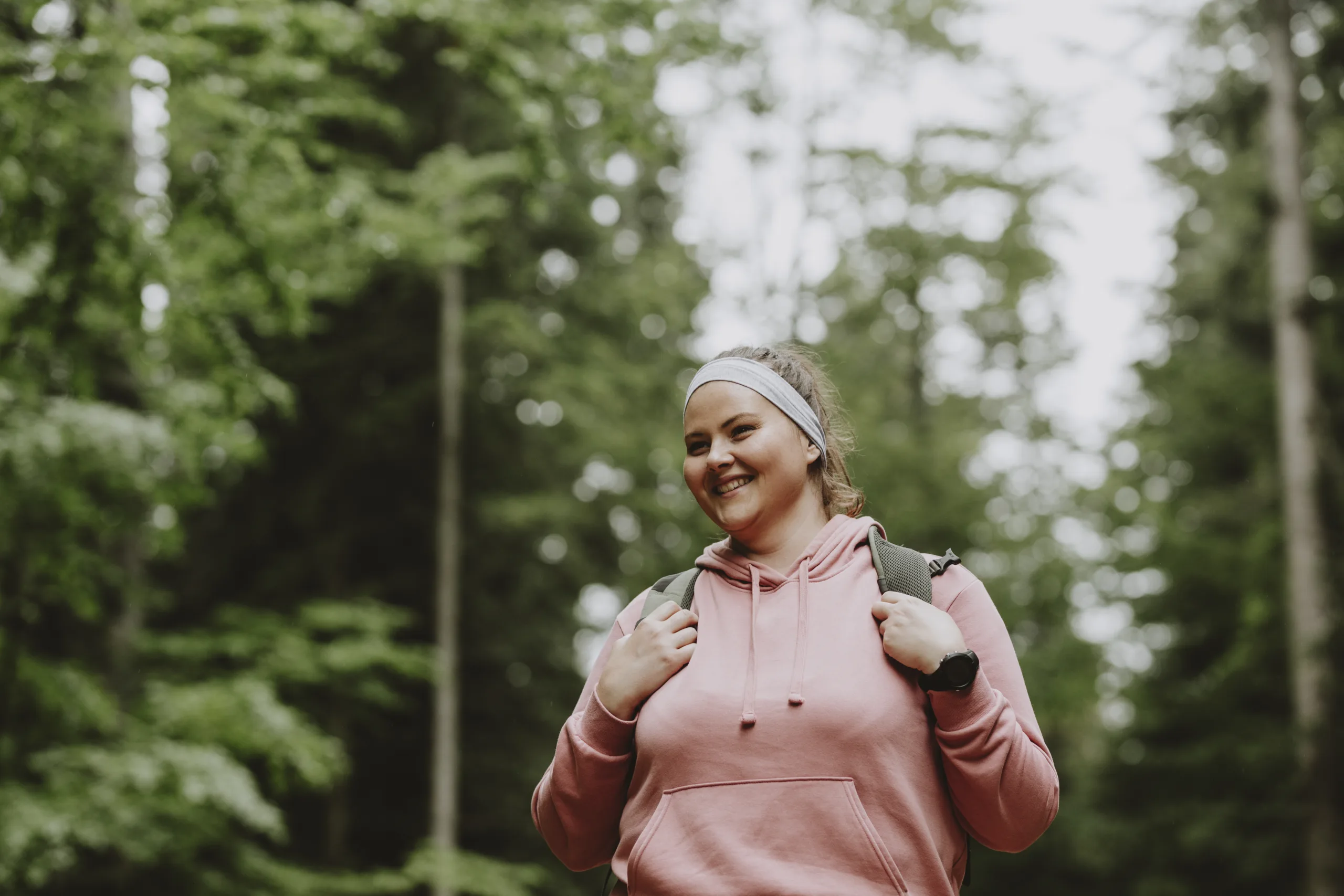 Woman hiking in forest smiling