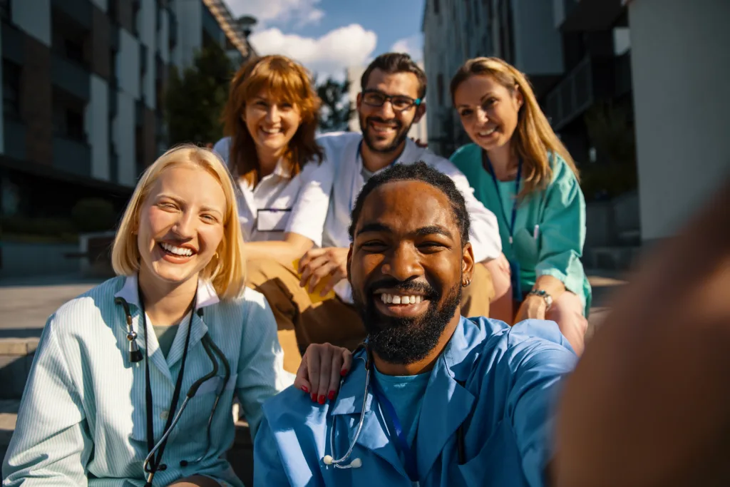 medicine students in uniform taking selfie in front of Hospital