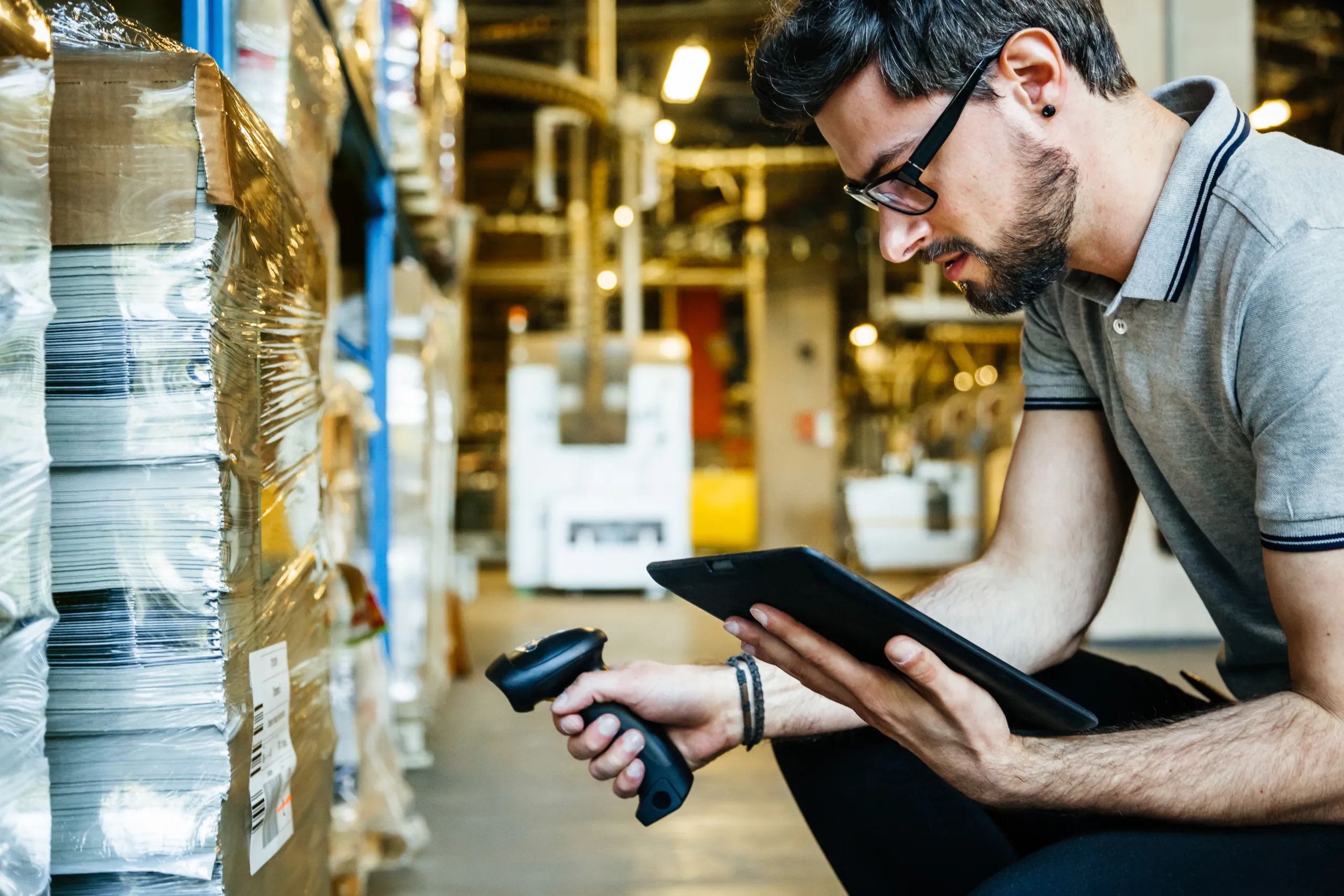 Worker With Bar Code Reader And Digital Tablet scanning in big warehouse