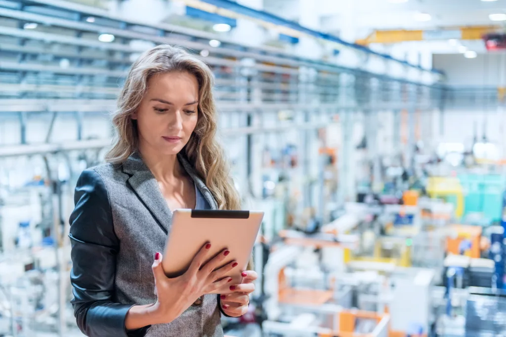 Woman looking at clipboard checklist working in factory