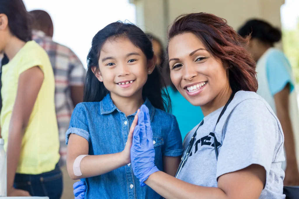 Young female patient and female doctor high five smiling