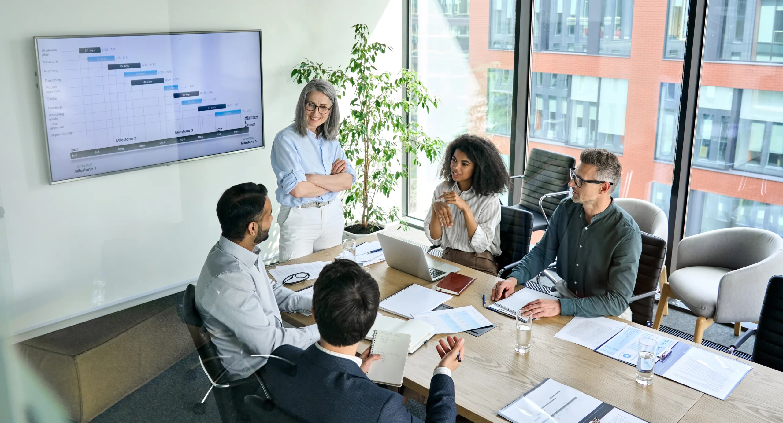 Team of professionals in a meeting around table and discussing projects and data