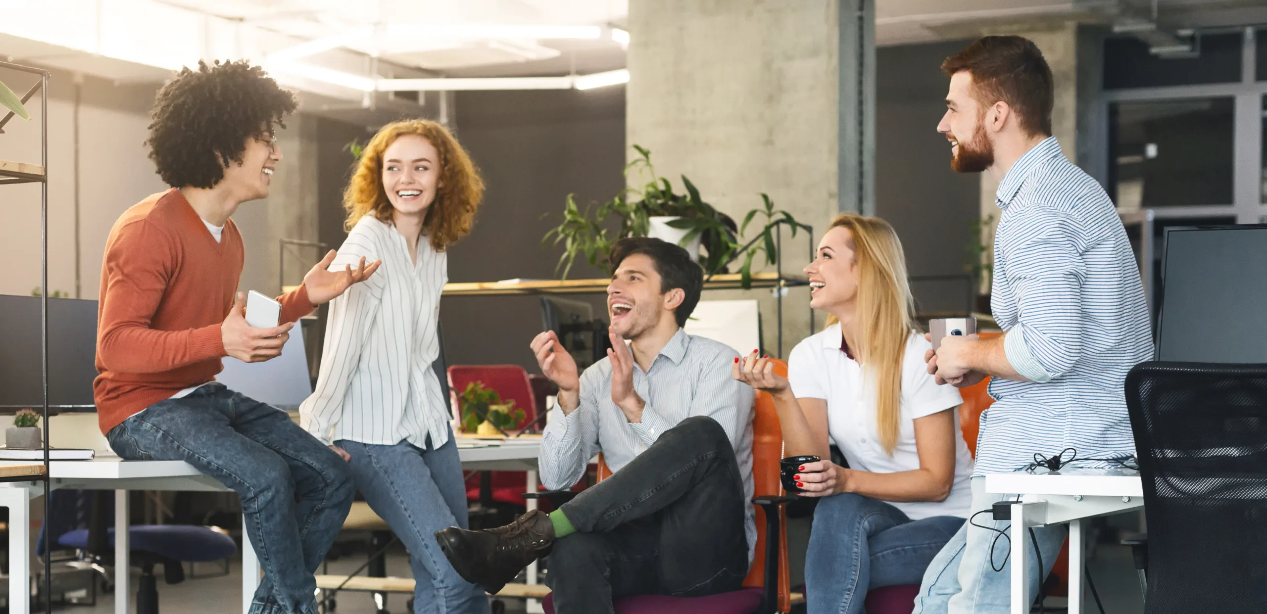 Friendship at workplace. Diverse millennial people having good talk at coworking space, panorama